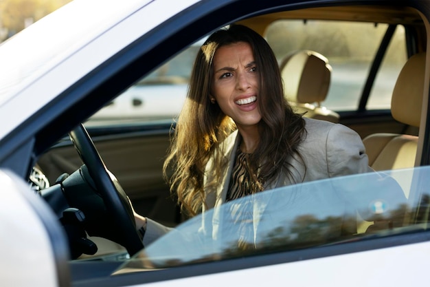 Mujer descontenta al volante de un coche cómodo está discutiendo Una chica moderna está conduciendo