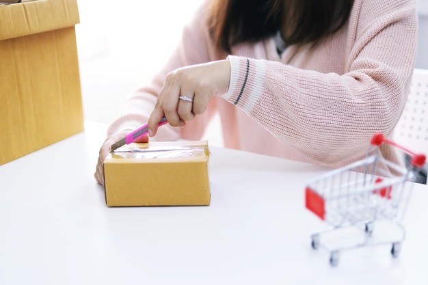 Mujer desempacando unboxing después de comprar ordenar compras en línea en casa