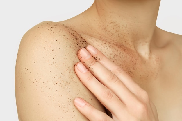 mujer desnuda aplicando exfoliante de café natural a su piel, cuidado de la piel y concepto de limpieza de la piel