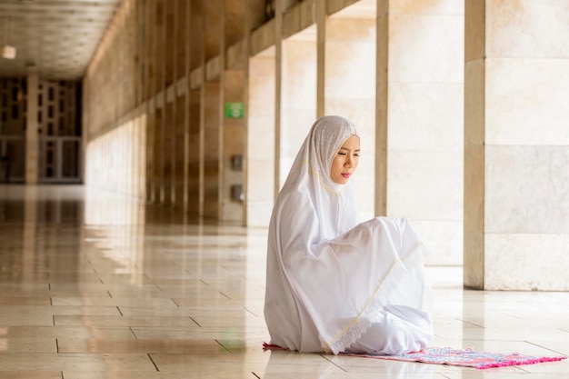 Mujer devota rezando a Alá en la mezquita