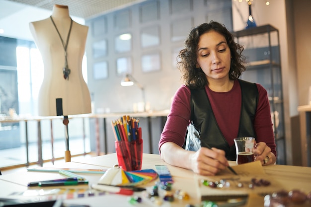 Mujer dibujando bocetos de joyas