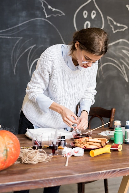 Mujer dibujando pintura líquida en jeringa