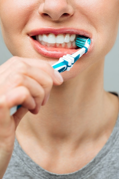 Foto mujer con dientes blancos sanos sostiene un cepillo de dientes y sonríe concepto de higiene bucal