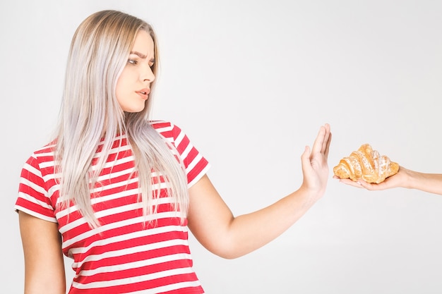 Mujer en dieta por concepto de buena salud. Mujer haciendo señal de no rechazar la comida chatarra o la comida rápida que tiene mucha grasa.