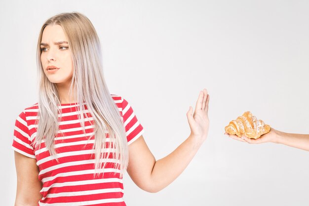 Mujer en dieta por concepto de buena salud. Mujer haciendo señal de no rechazar la comida chatarra o la comida rápida que tiene mucha grasa.