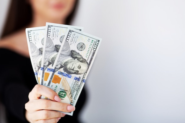 Mujer con dinero en el lugar de trabajo. Concepto de negocio