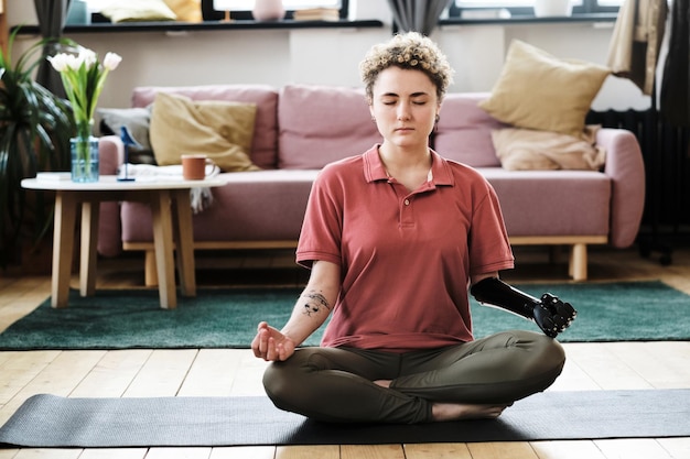 Mujer con discapacidad meditando en casa