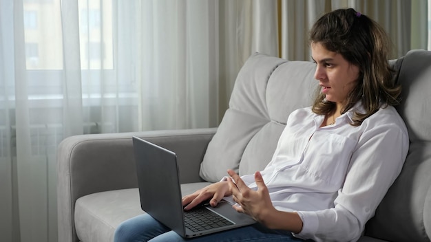 Mujer discapacitada habla en una entrevista de trabajo a través de Skype en una laptop