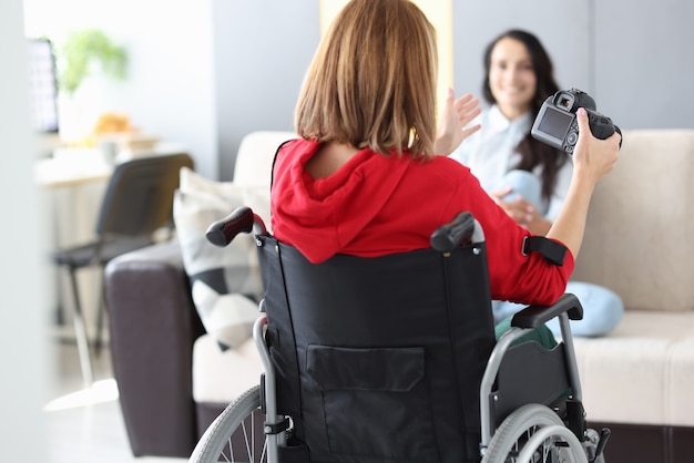 Mujer discapacitada en silla de ruedas fotografía apartamento de niña. Trabajar por el concepto de personas de emociones positivas.