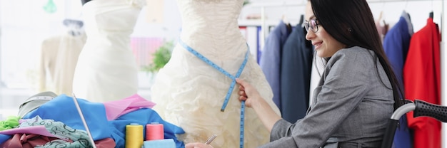 Mujer discapacitada en silla de ruedas tomando medidas desde el desarrollo de negocios de vestido de novia para