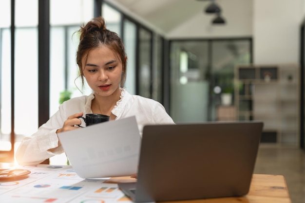 Mujer discutiendo tablas de análisis o gráficos en la mesa del escritorio y usando una computadora portátil Cerrar el análisis femenino y el concepto de estrategia