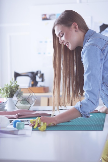 Mujer diseñadora de moda estadounidense que trabaja en el taller