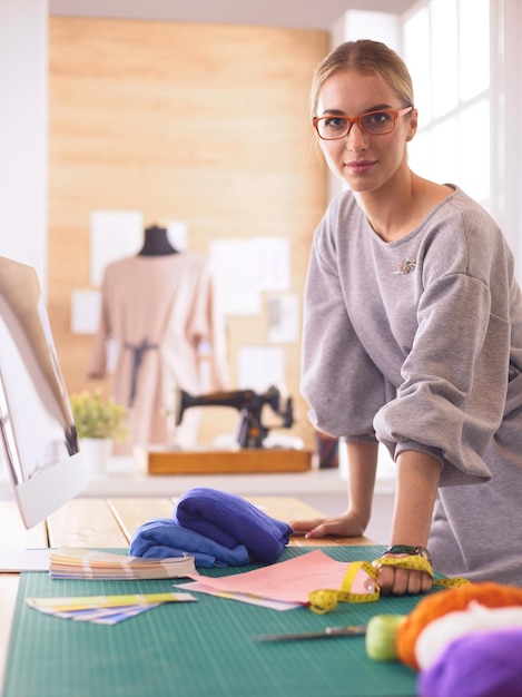 Mujer diseñadora de moda trabajando en sus diseños en el estudio.