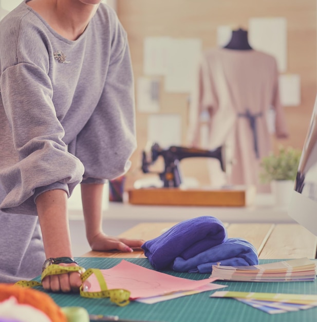 Foto mujer diseñadora de moda trabajando en sus diseños en el estudio.