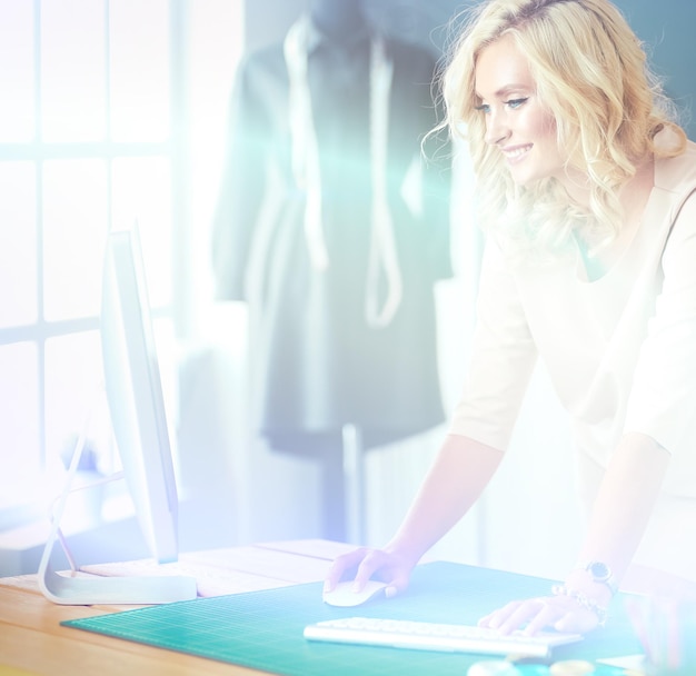 Mujer diseñadora de moda trabajando en sus diseños en el estudio.