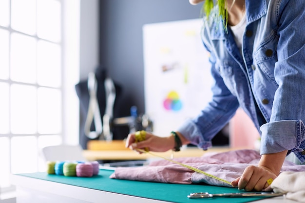 Mujer diseñadora de moda trabajando en sus diseños en el estudio