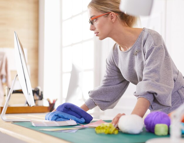 Mujer diseñadora en taller mirando portátil