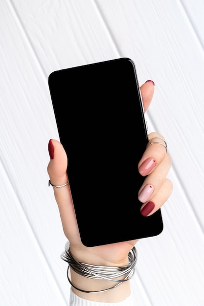 Mujer con diseño minimalista de manicura rosa primavera verano con smartphone. Trabajar desde casa concepto de negocio femenino