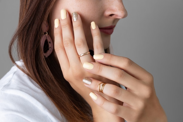 Mujer con diseño de uñas amarillo brillante.