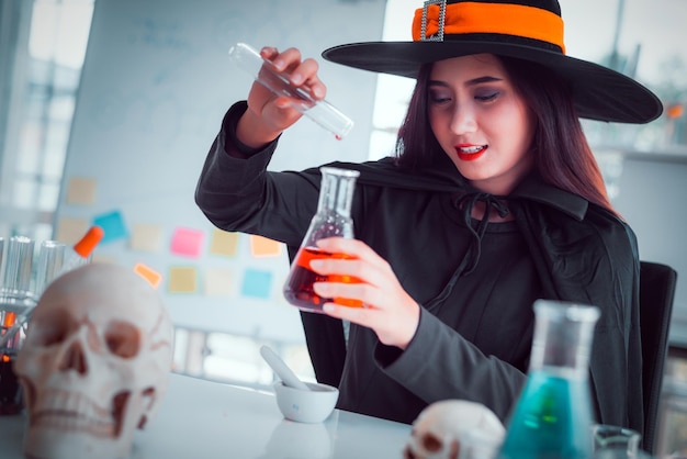 Foto mujer con disfraz de bruja haciendo un experimento científico en el laboratorio