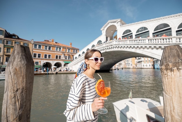 Mujer disfruta de una bebida de verano mientras viaja en venecia