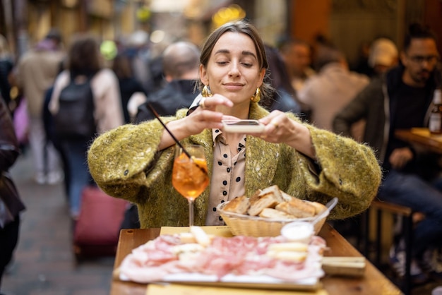 Mujer disfruta de la gastronomía italiana en el restaurante al aire libre