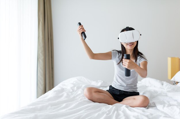 Mujer disfruta jugar con VR en casa