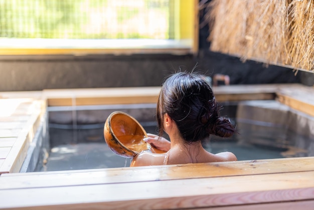 La mujer disfruta del onsen en el área interior