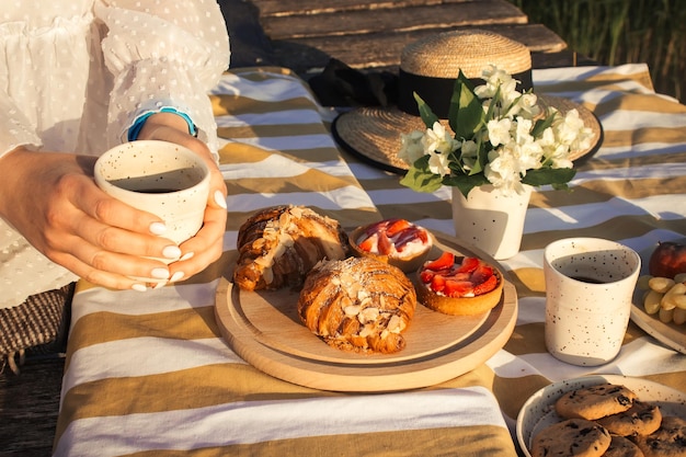 La mujer disfruta de un sabroso café en un picnic al aire libre