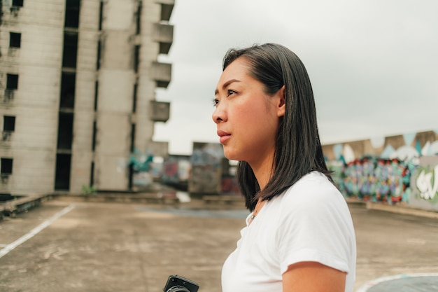 La mujer disfruta de tomar la foto de un edificio abandonado desconocido.