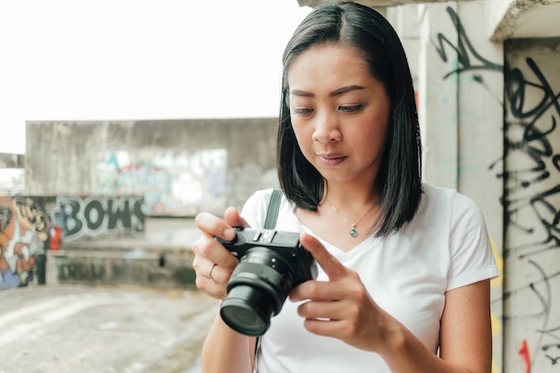 La mujer disfruta de tomar la foto de un edificio abandonado desconocido.