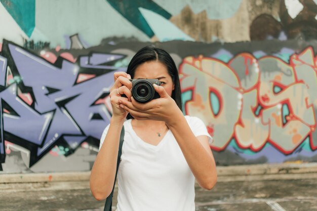 La mujer disfruta de tomar la foto de un edificio abandonado desconocido.