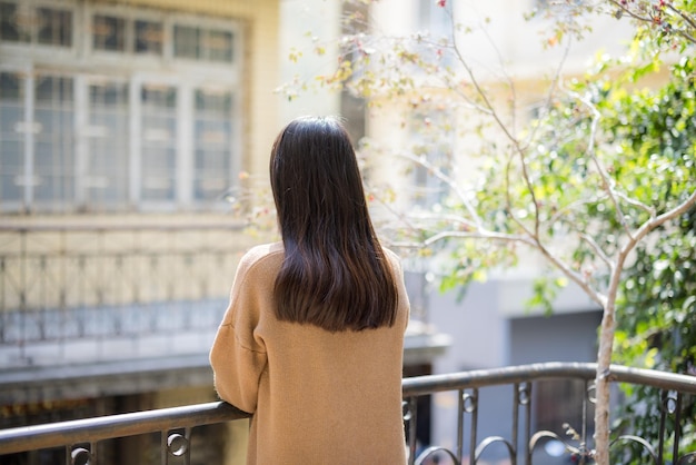 La mujer disfruta de la vista fuera del balcón