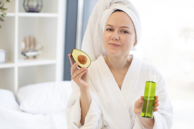 Mujer disfrutando del aceite facial de aguacate durante el día de spa en casa