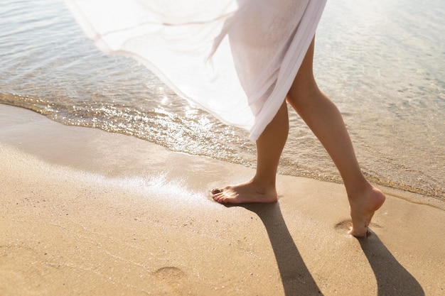 Foto mujer disfrutando de las arenas en la playa