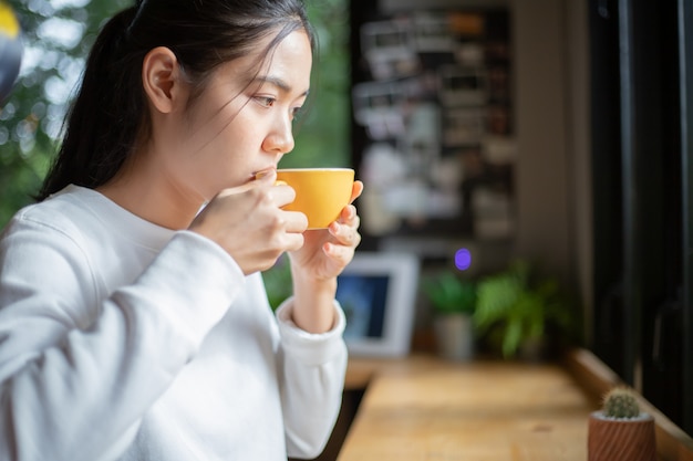 Mujer disfrutando de bebidas bebidas en la mañana.