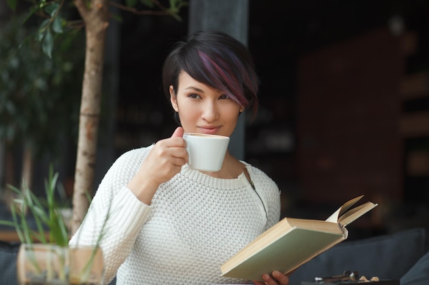 Mujer disfrutando de café y libro