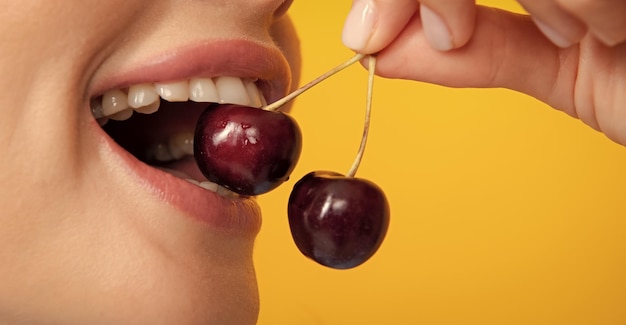 Foto mujer disfrutando de la cereza dulce fresca boca femenina comiendo cereza dulce boca femenina de primer plano degustación