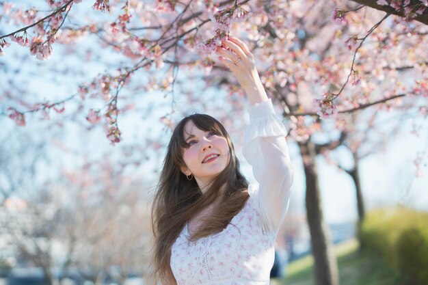 Una mujer disfrutando de los cerezos en flor