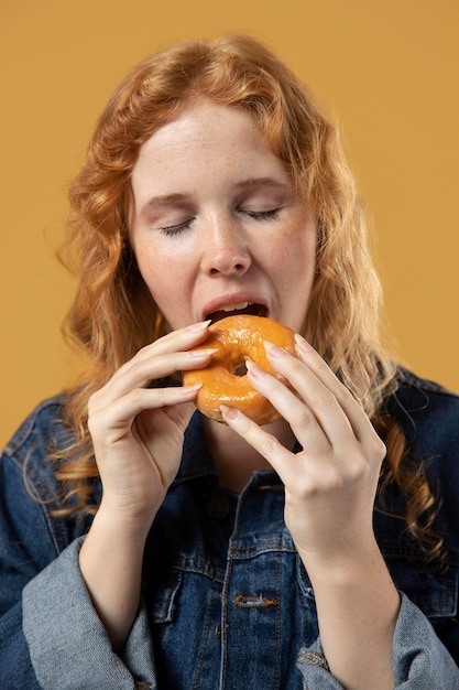 Foto mujer disfrutando de comer una rosquilla