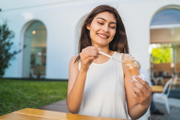 Mujer disfrutando y comiendo un helado.