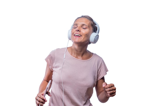 Mujer disfrutando escuchando música y bailando con su teléfono inteligente