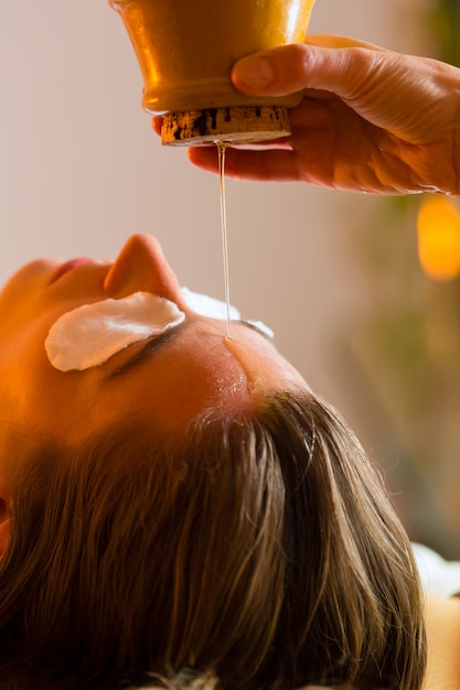 Mujer disfrutando de un masaje de aceite Ayurveda