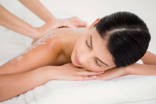 Mujer disfrutando de un masaje exfoliante de sal