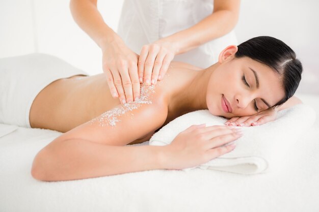 Mujer disfrutando de un masaje exfoliante de sal