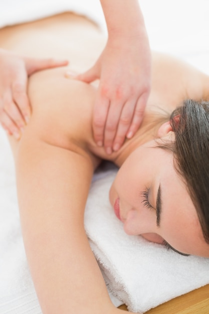 Mujer disfrutando de masaje de hombro en el spa de belleza