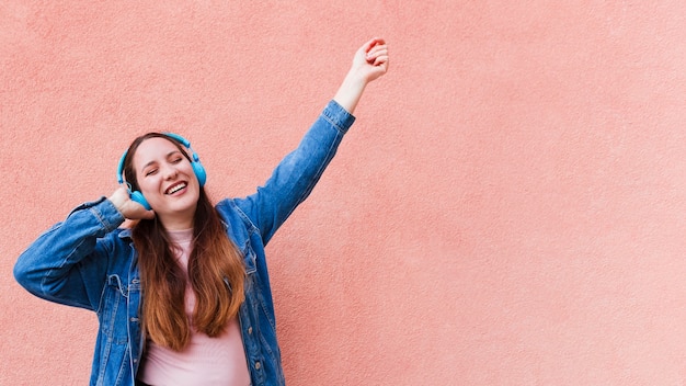 Foto mujer disfrutando de la música en los auriculares con espacio de copia