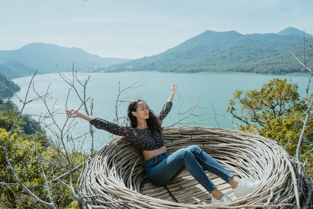 Mujer disfrutando de la naturaleza desde la cima de la colina