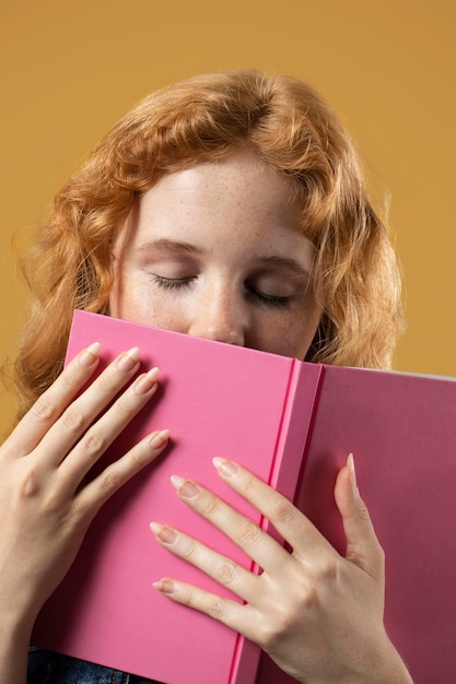 Foto mujer disfrutando del olor de un libro