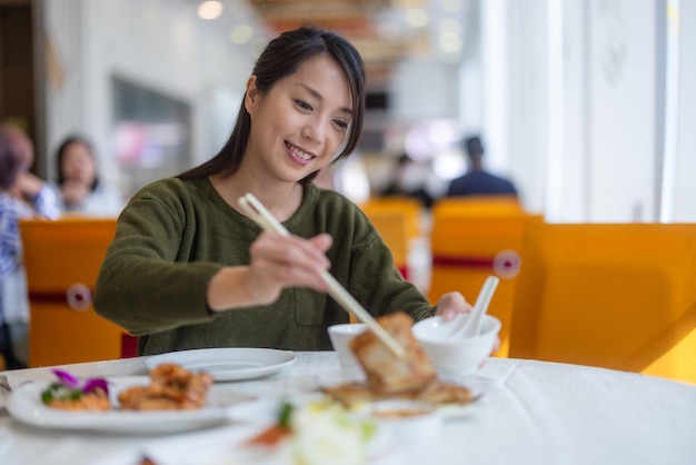 Mujer disfrutando de su almuerzo en un restaurante chino